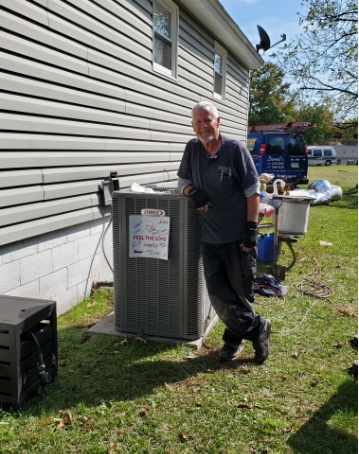 Daniel's Heating and AC employee standing in front of an air conditioning unit